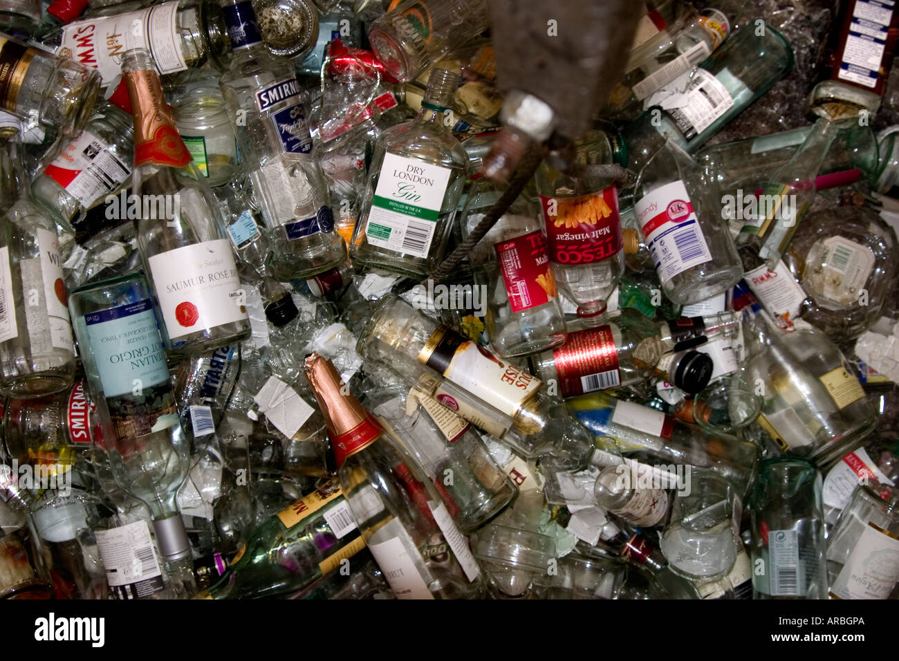 Bouteilles en verre clair au fond d'un récipient de collecte de recyclage en attente Banque D'Images