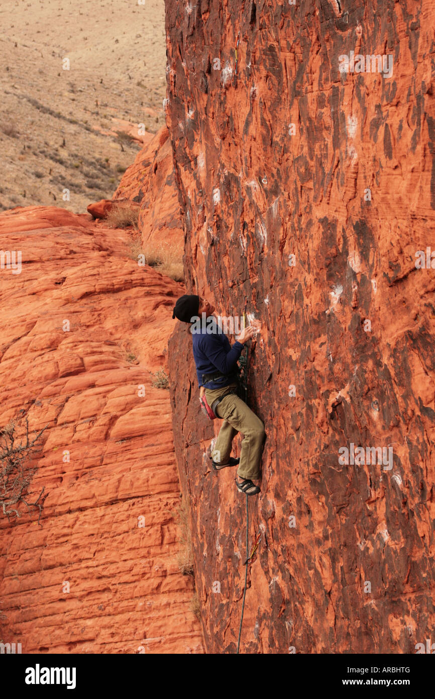 Femme Asiatique laisse climber grimpe dans un grès rouge verticale rock face Banque D'Images