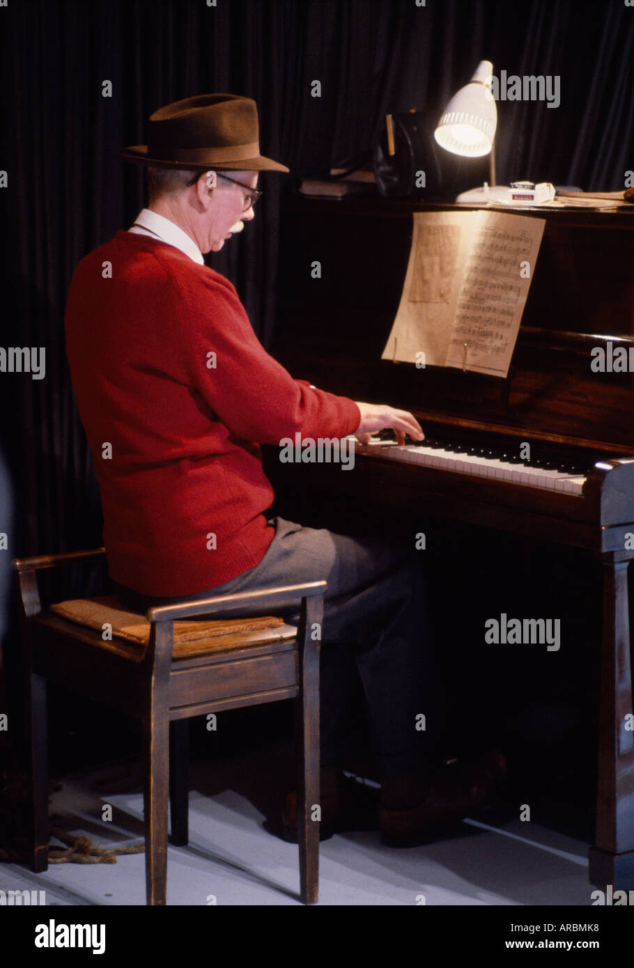 L'homme jouant du piano sur plateau de tournage en Angleterre en Grande-Bretagne au Royaume-Uni Royaume-Uni. La vieillesse des personnes âgées retraite Culture musicale Music Entertainment Banque D'Images