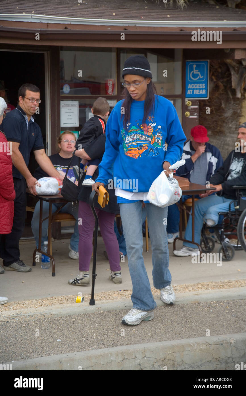 Une femme à faible revenu handicapés recueille des dons en nourriture pour un dîner de Noël dans un refuge pour sans-abri Banque D'Images