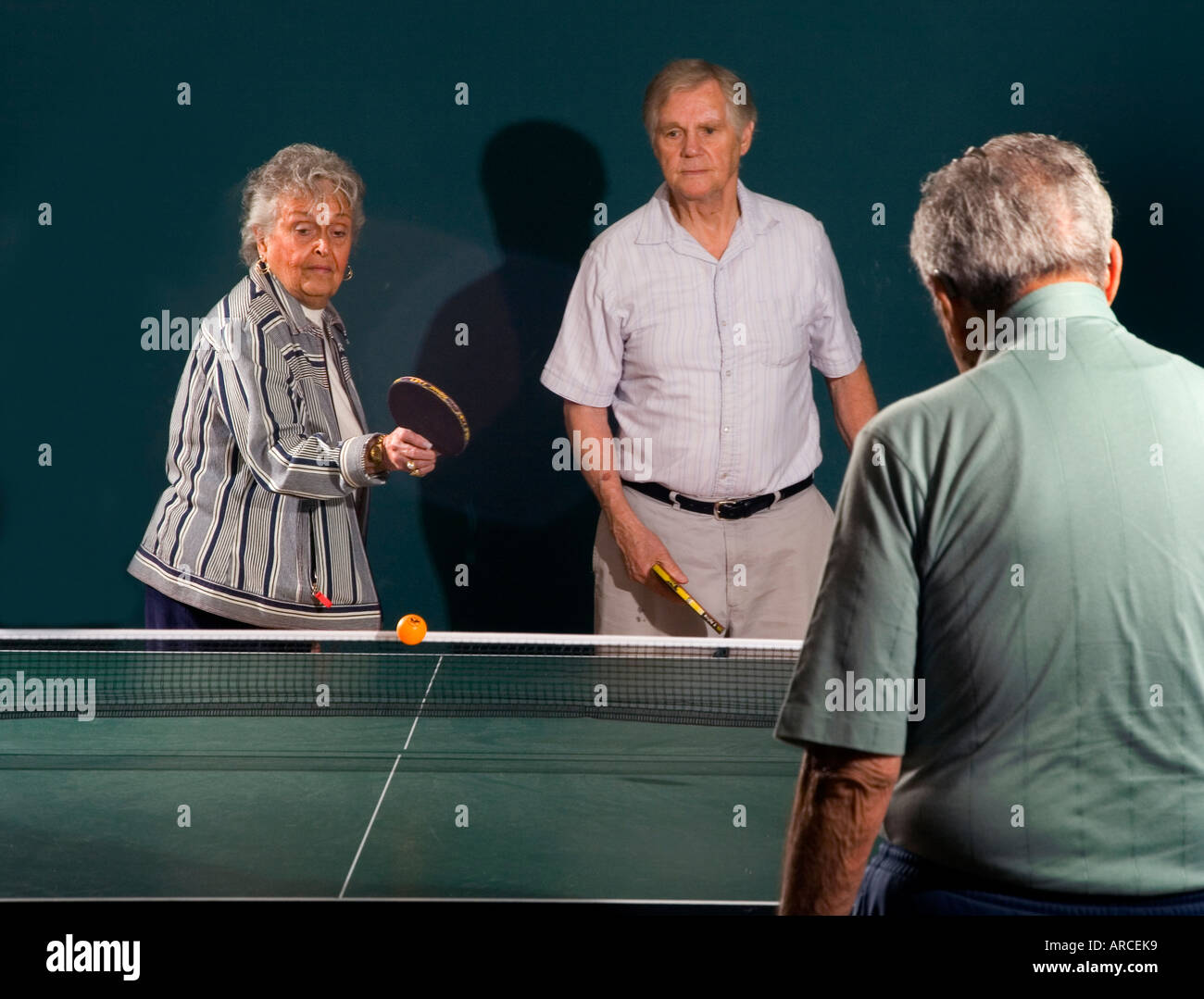 Les hommes âgés et les femmes âgées de leur 70 s pour leur 90 s jouer ping pong Banque D'Images