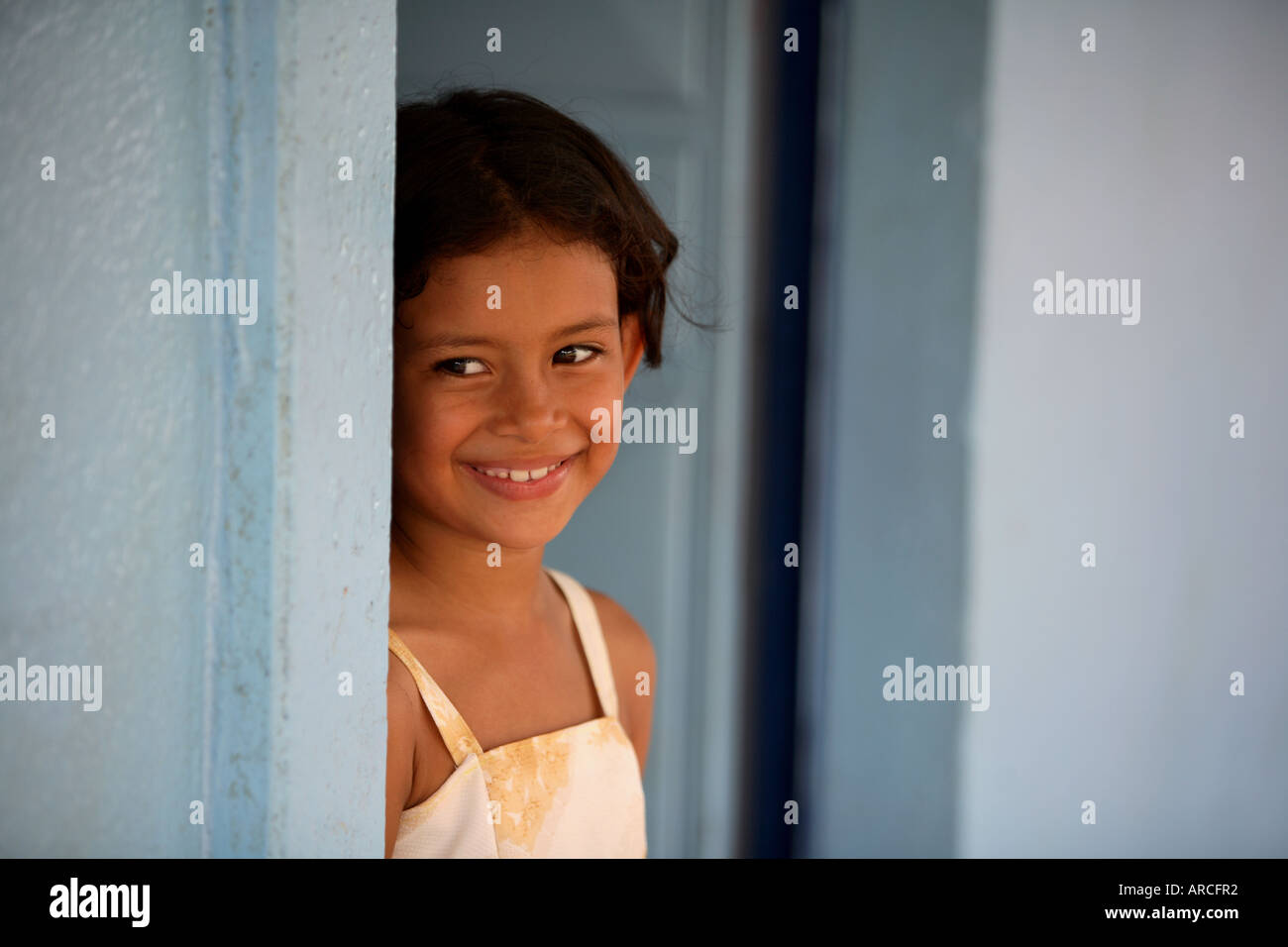 Portrait de la belle petite fille locale à la porte bleue ronde lors d'une visite à une école du Costa Rica sur une aventure en famille maison de vacances Banque D'Images