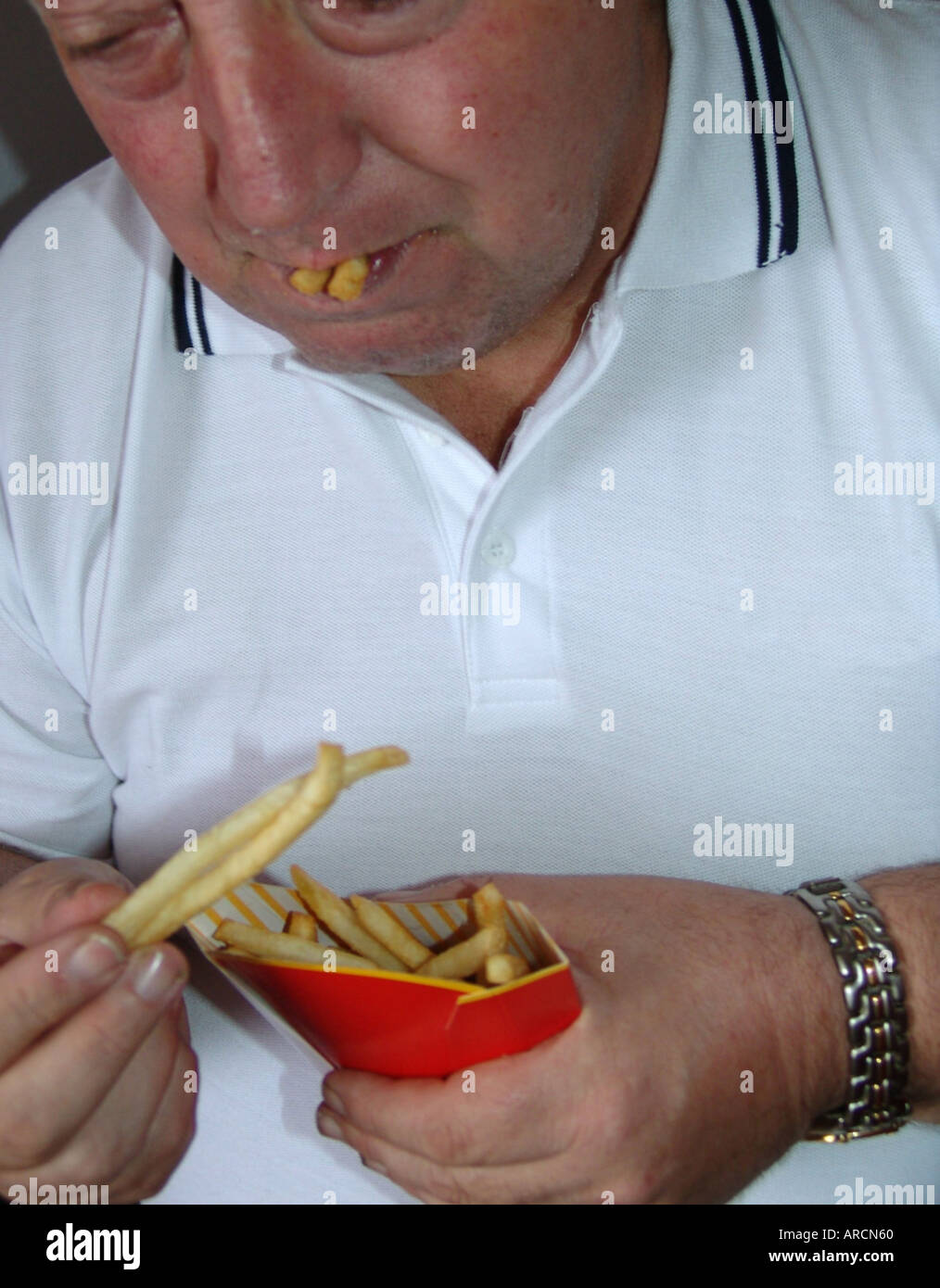 L'excès de manger une nourriture rapide mâle fries UK 2005 Banque D'Images