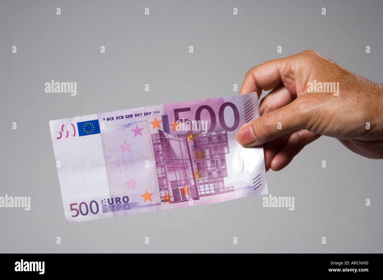 Un mâle main tenant ou offrant un billet de cinq cents euro 500 Banque D'Images