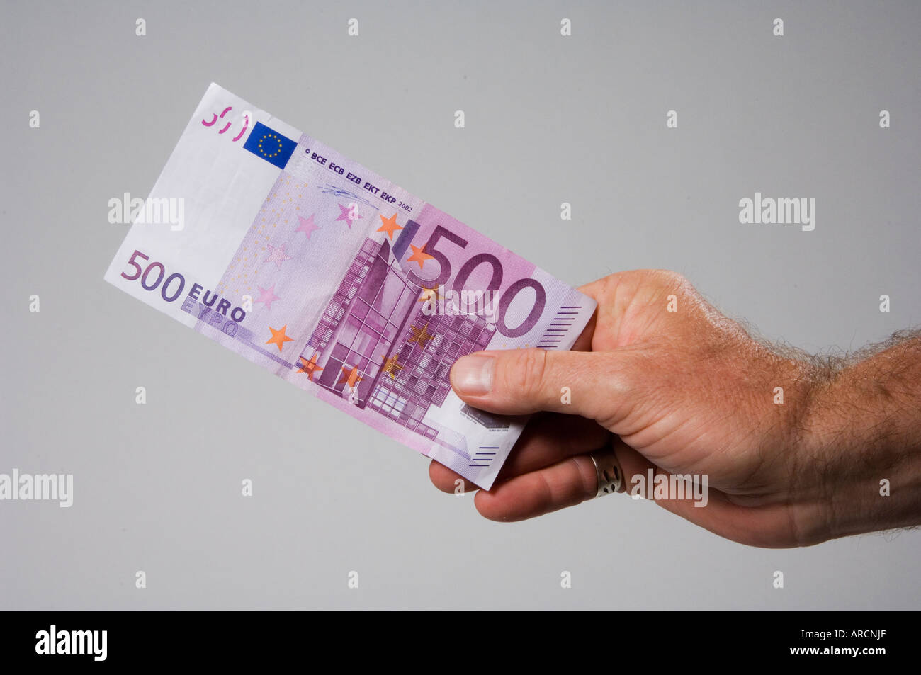 Un mâle main tenant ou offrant un billet de cinq cents euro 500 Banque D'Images