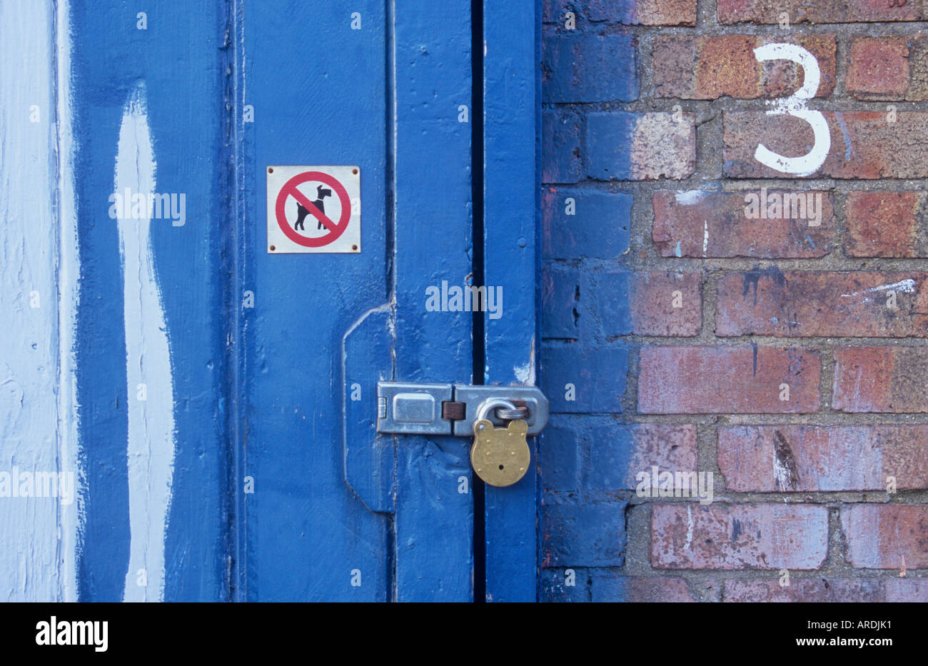 Détail de l'atelier à la porte cadenassée ou garage ou unité industrielle avec aucun signe iconique chiens et numéro 3 sur le mur Banque D'Images