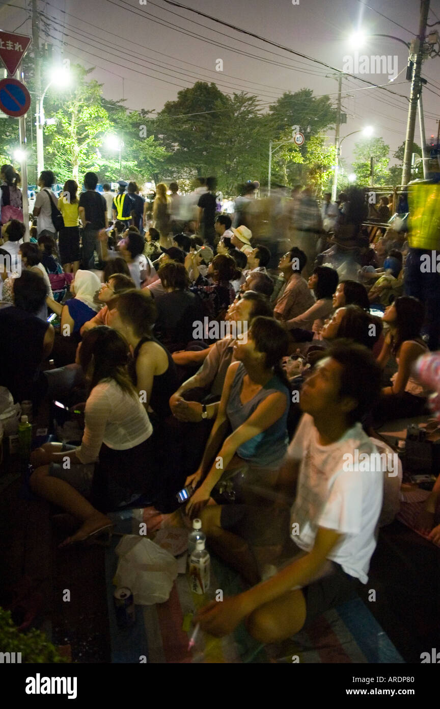 Des foules énormes s'asseoir et regarder les feux d'artifice de la rivière Sumida à Tokyo au Japon Banque D'Images