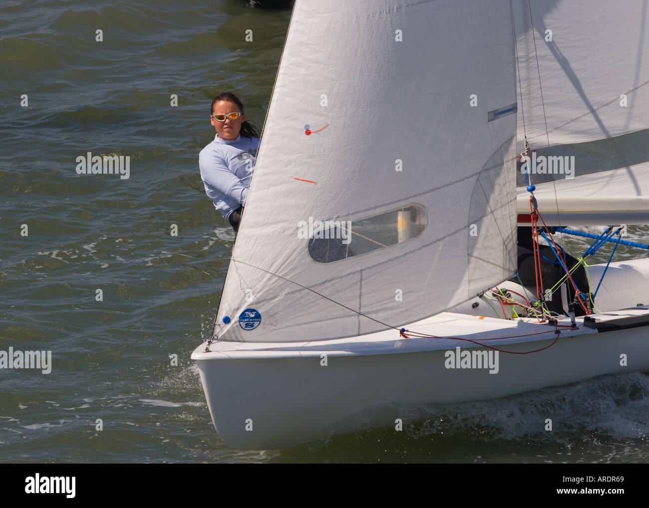Membre de l'équipage féminin suspendu par le fil en trapèze classe Olympique 470 canot de course à pleine voile port de Lymington en Angleterre Banque D'Images