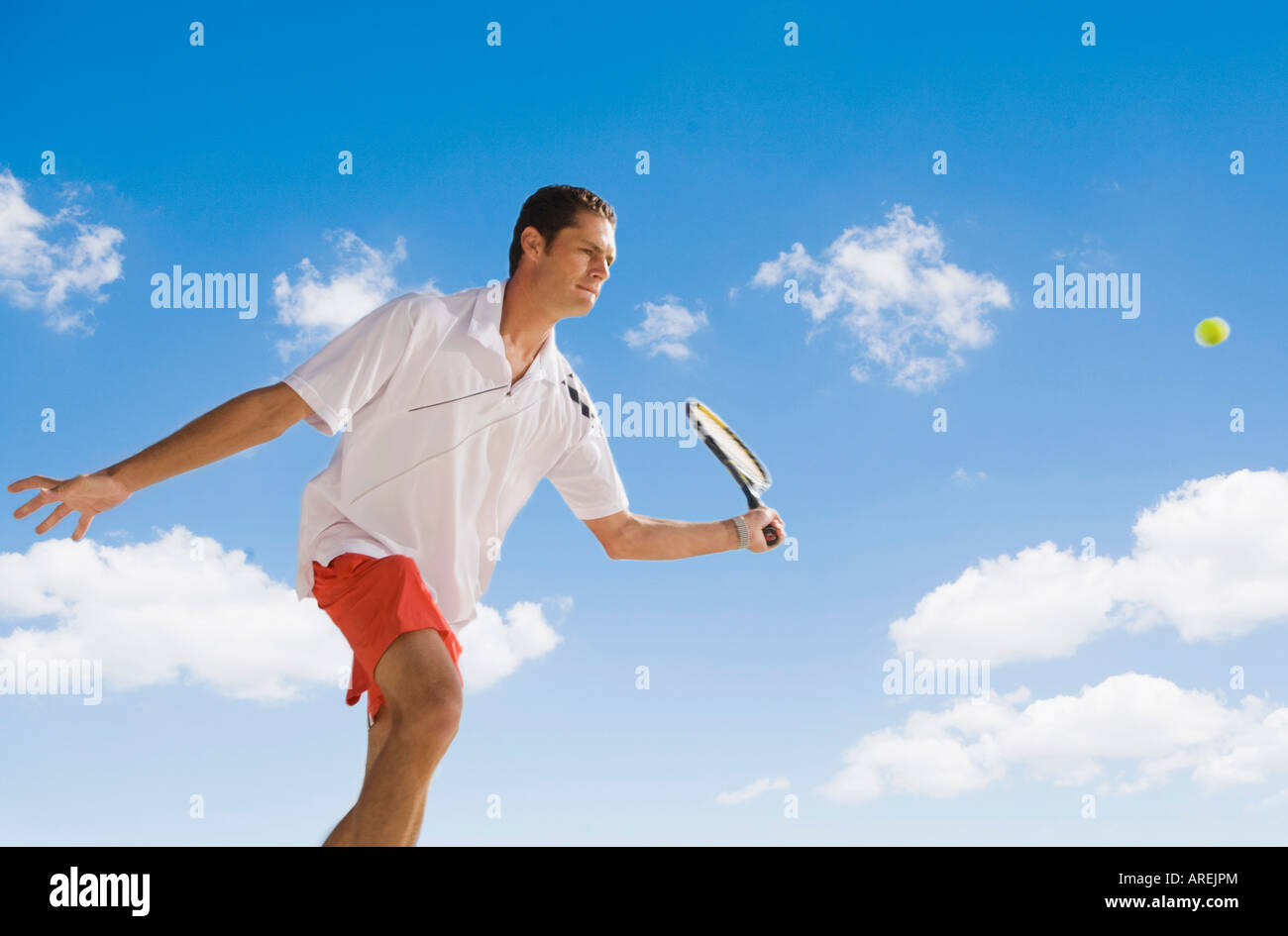 Homme sautant à jouer au tennis smash shot Banque D'Images
