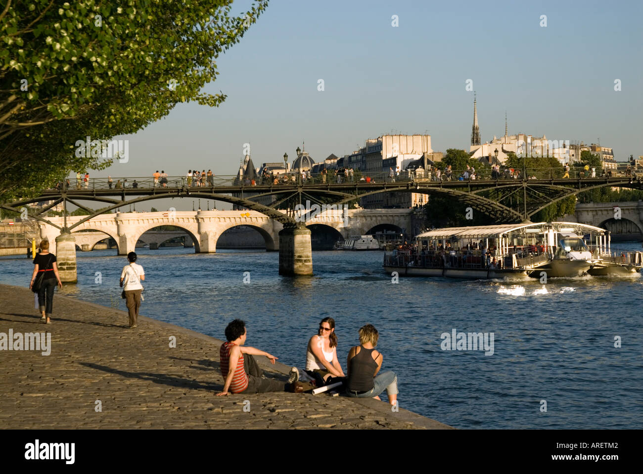 Les gens assis à côté de la Seine, Paris France Banque D'Images