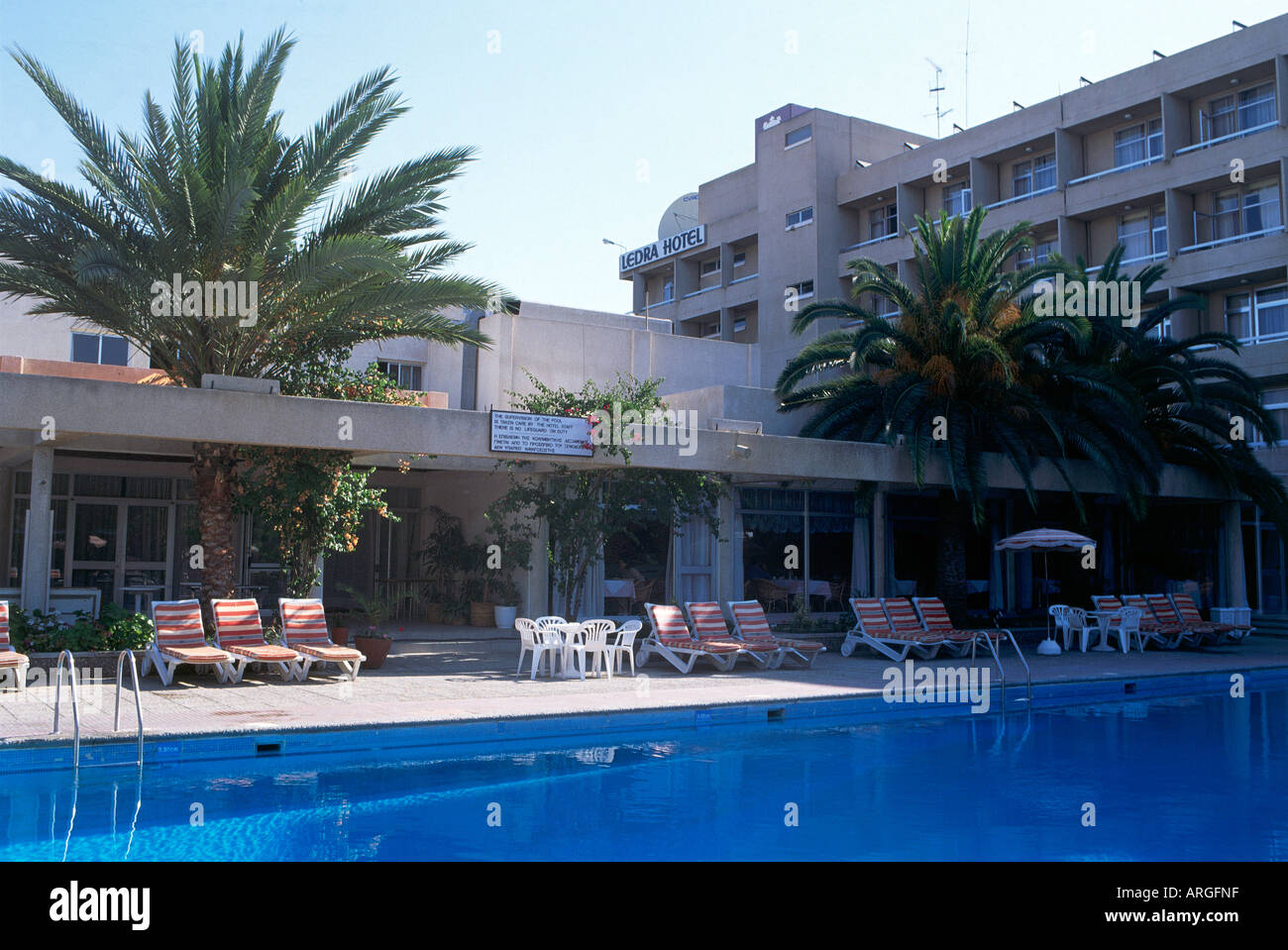 Palmiers ornementaux ajouter à l'atmosphère de refroidissement à la piscine de l'hôtel Ledra Hotel Nicosia Banque D'Images