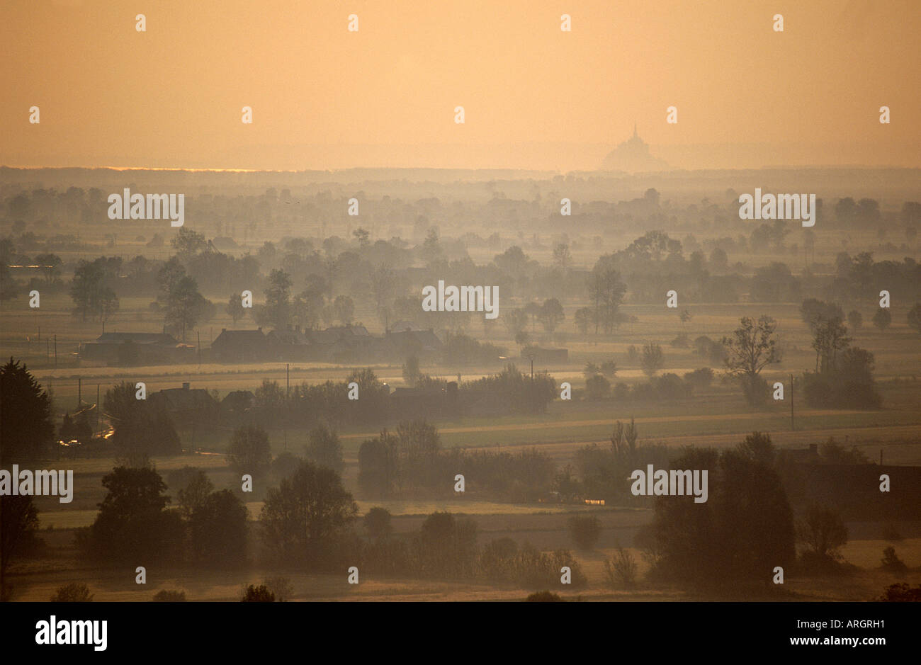 La mer et la forme caractéristique de la Mont St Michel vu du Mont Dol à travers un brouillard ramollir la mosaïque de champs sur les polders autour de Dol de Bretagne Banque D'Images