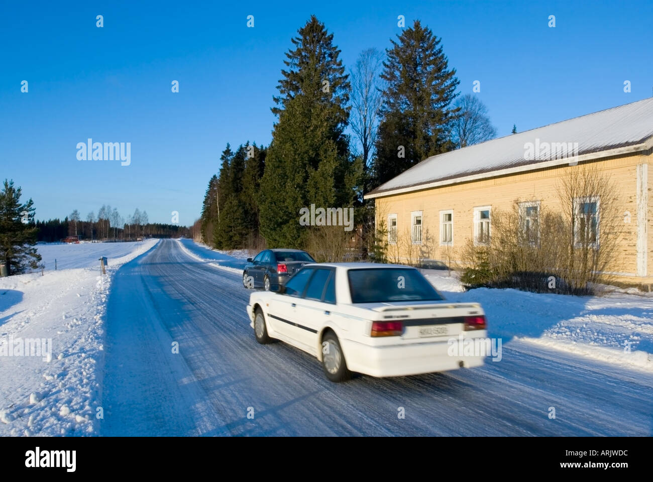 Voiture blanche conduite sur route glacée glissante au Winter , Finlande Banque D'Images
