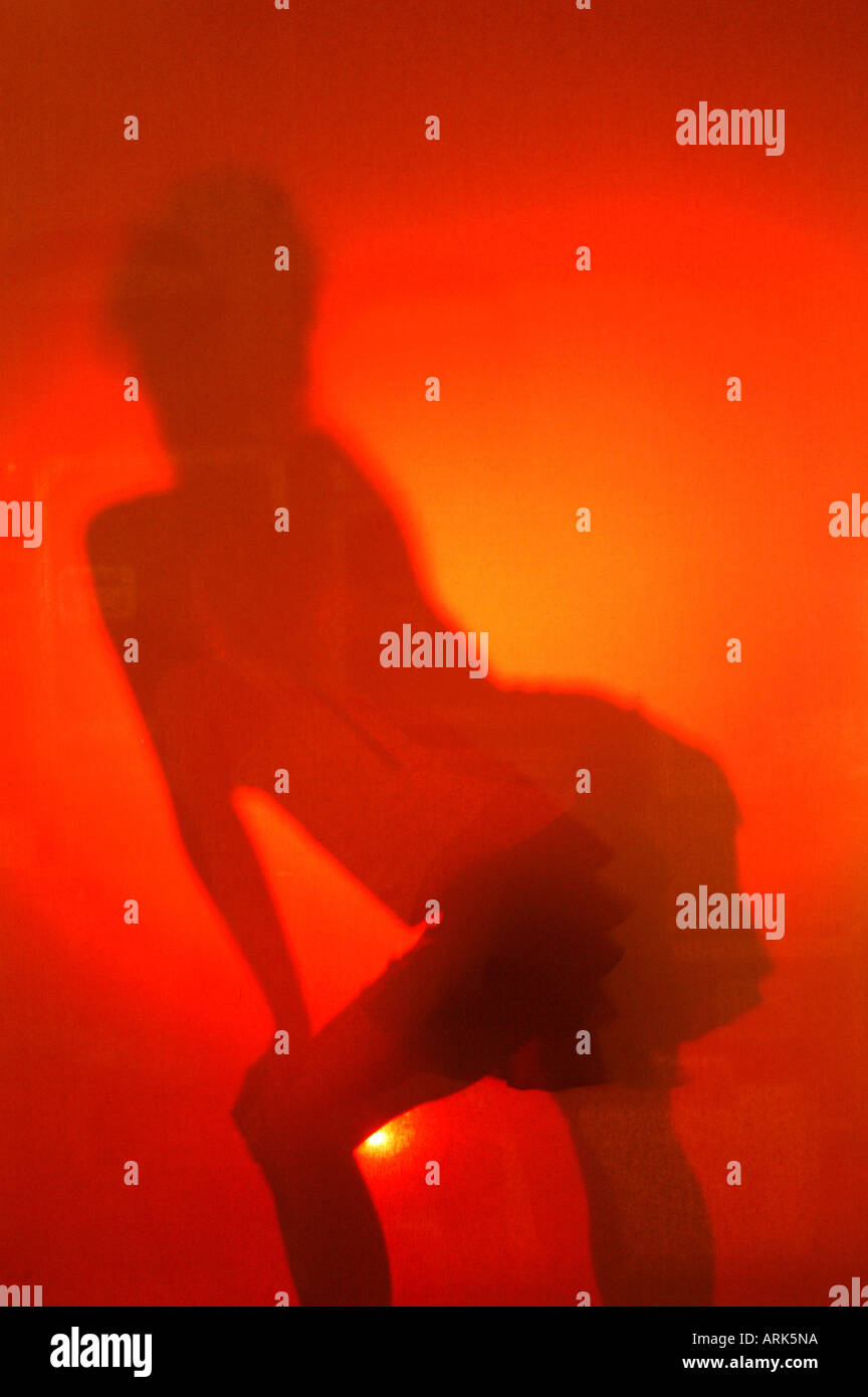 Photo symbolique : silhouette d'un gogo danseur dans une discothèque. Danse, danse, danse gogo. Banque D'Images