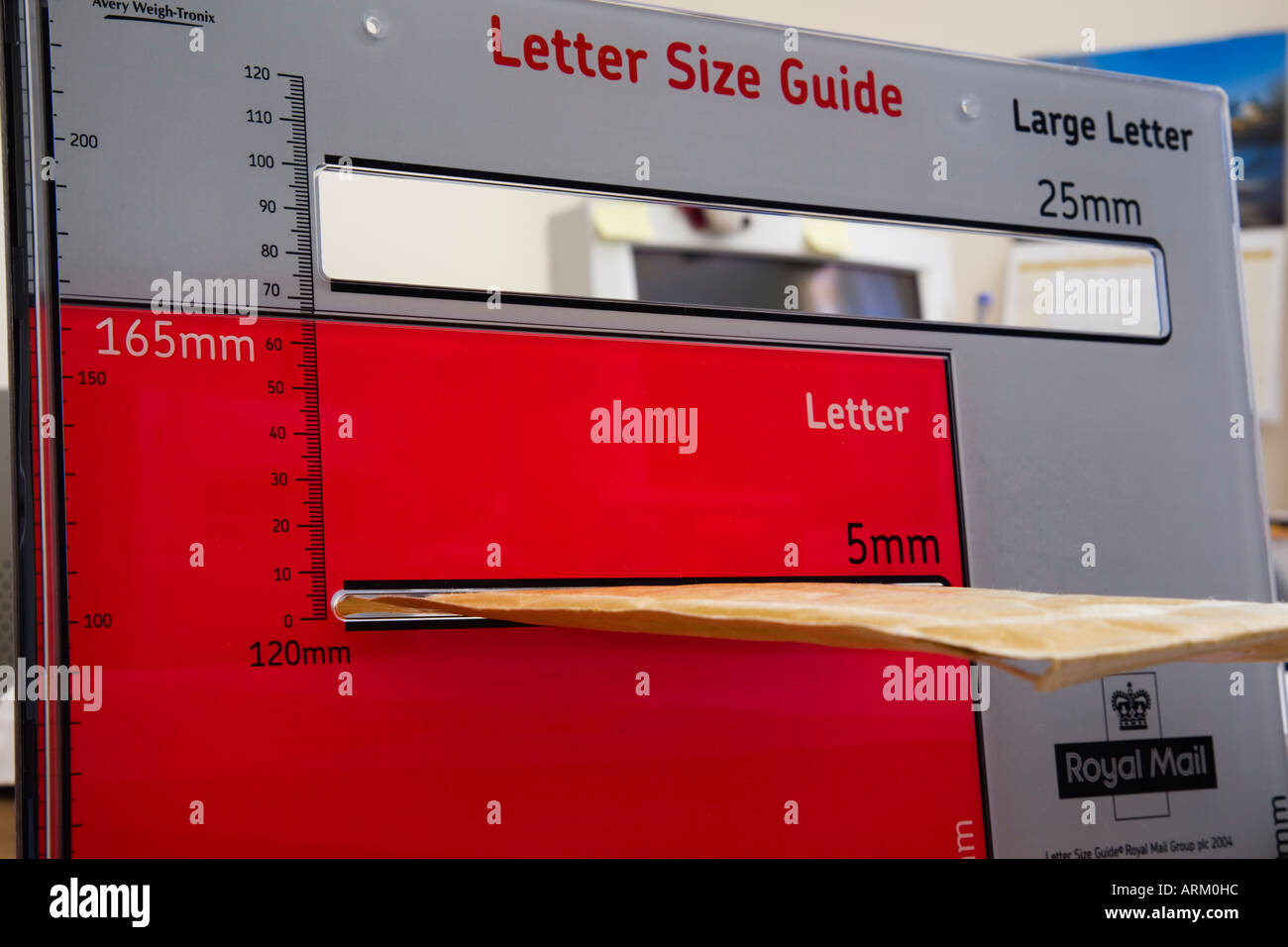 À l'AIDE DE LA ROYAL MAIL GUIDE DE FORMAT LETTRE avec enveloppe brune qui est mesuré dans les petites 5mm d'épaisseur sur la section rouge pour standard Banque D'Images