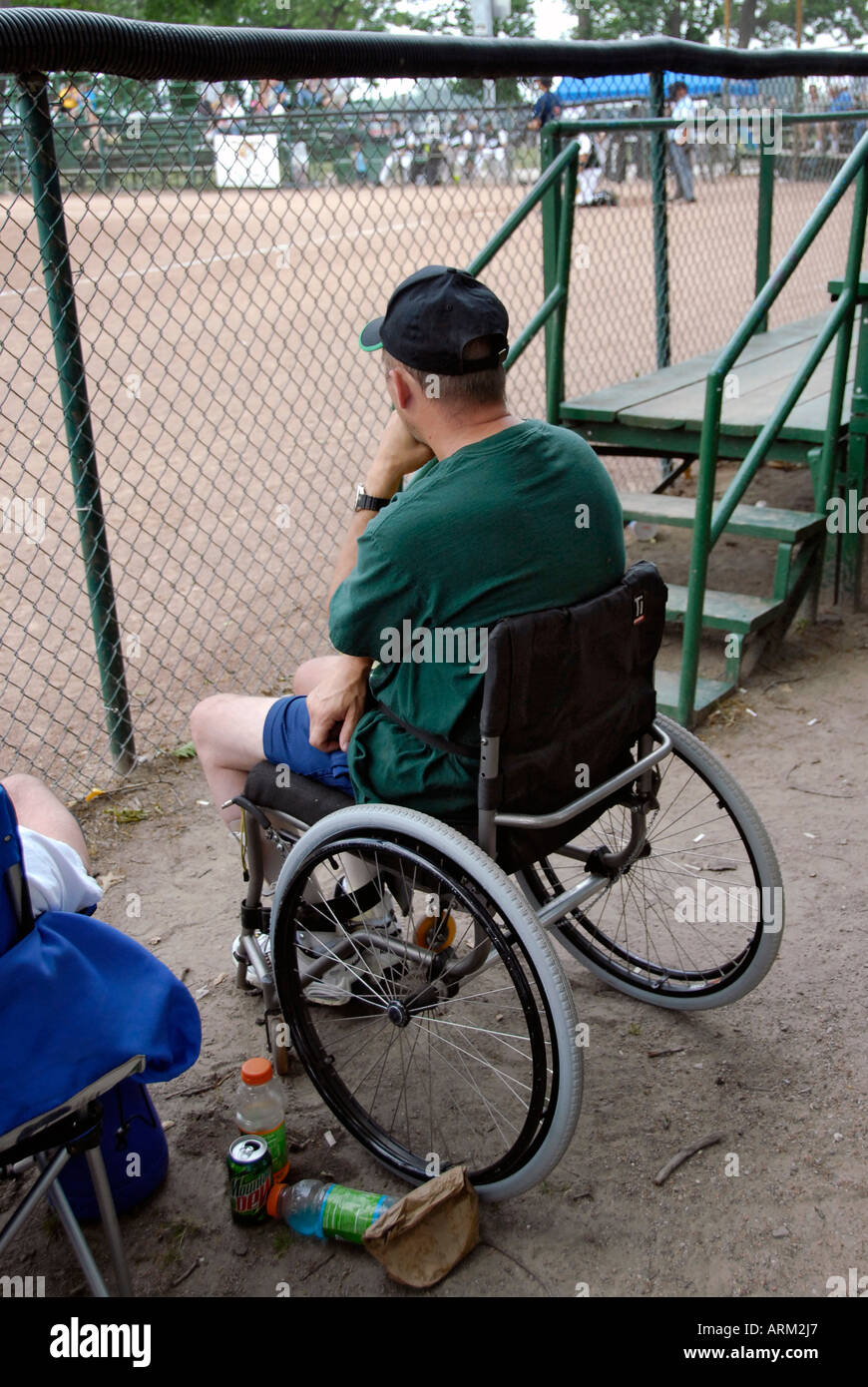 Montres homme handicapé à un match de baseball alors qu'il était assis dans un fauteuil roulant Banque D'Images