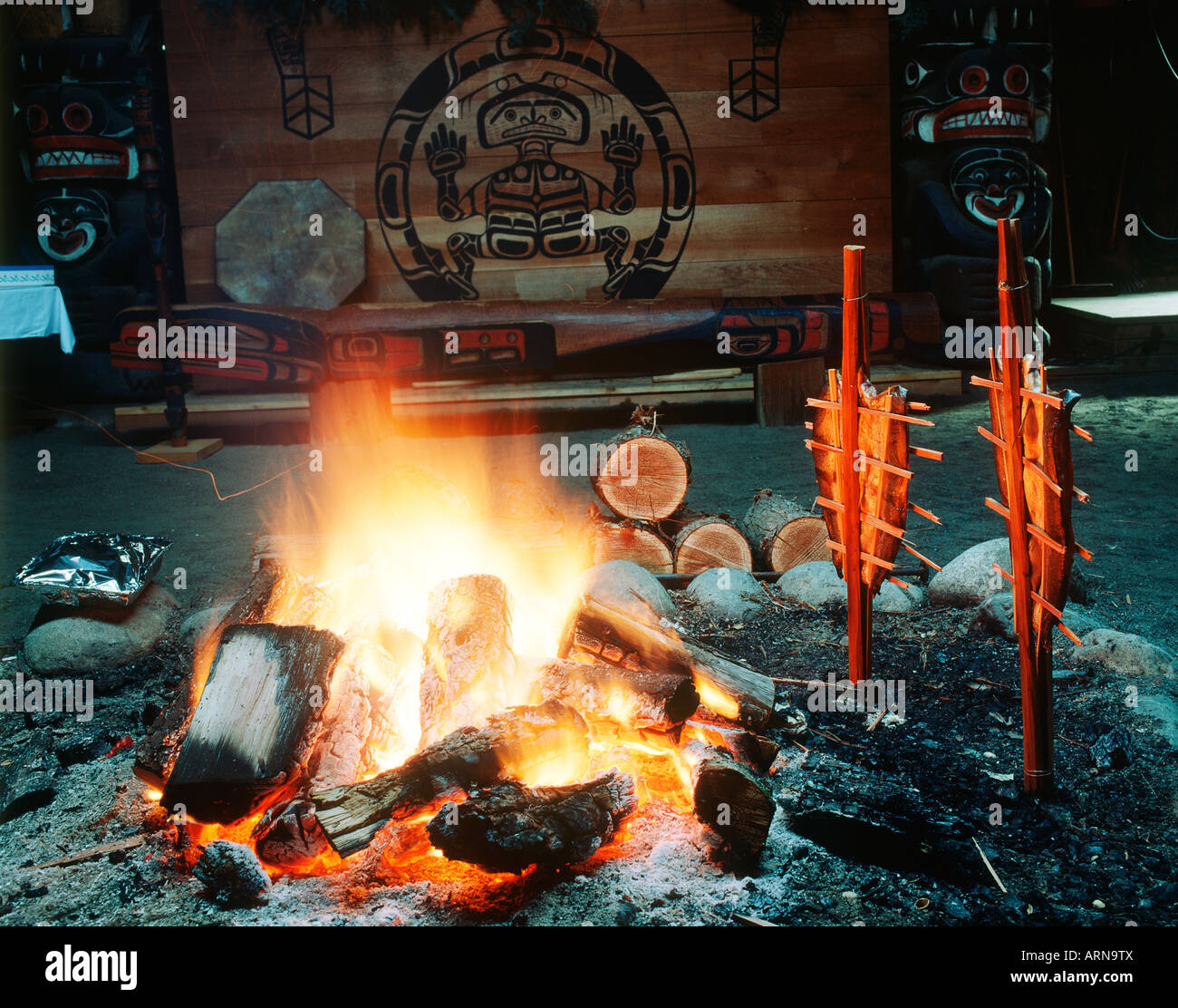 La culture des Premières Nations, Mungo Martin House, ouvert le feu avec des saumons sur pieux de cèdre, de la Colombie-Britannique, Canada. Banque D'Images