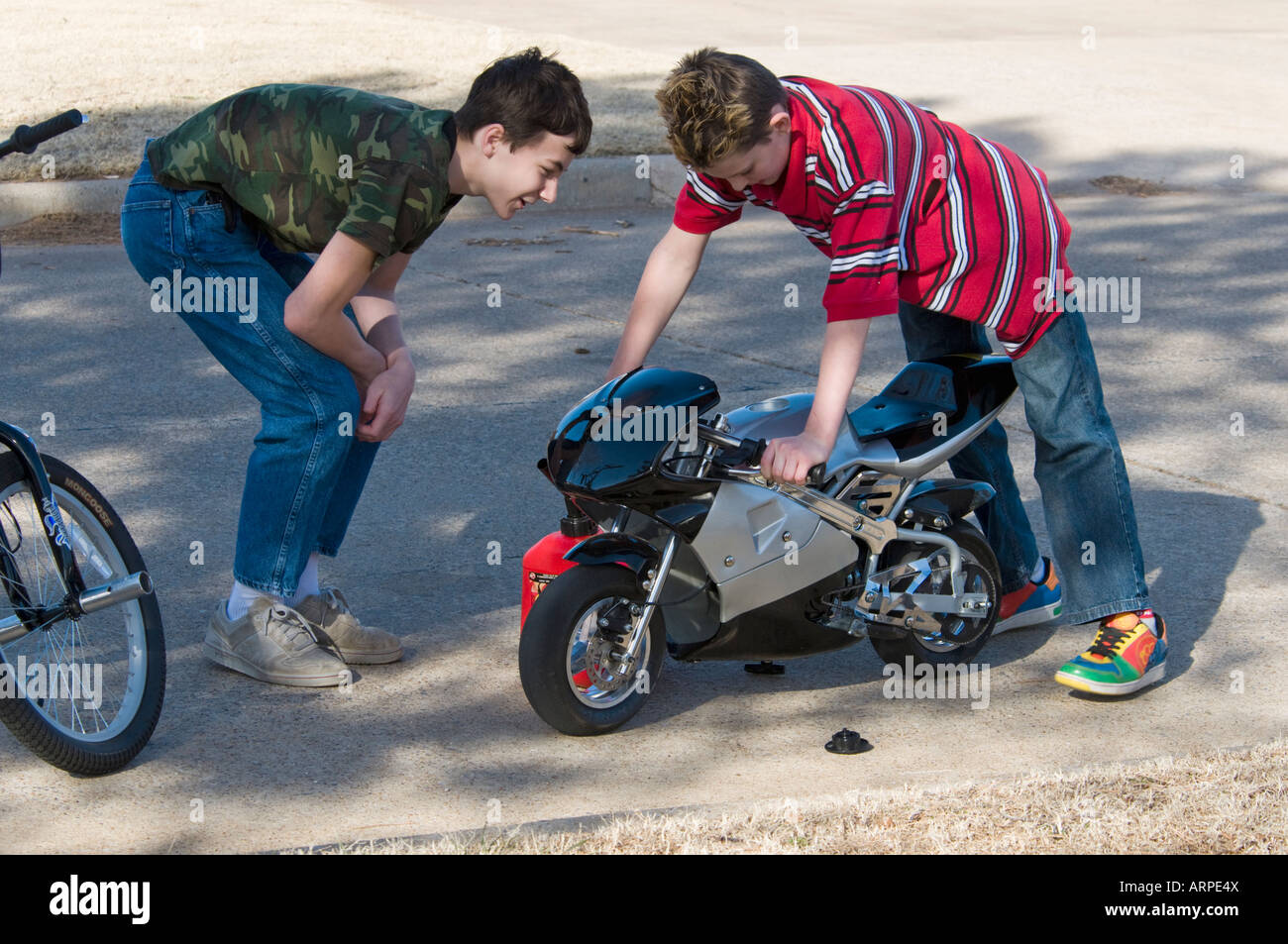 Deux adolescents une étude pocket bike motorisée qui a quitté en cours d'exécution. Banque D'Images