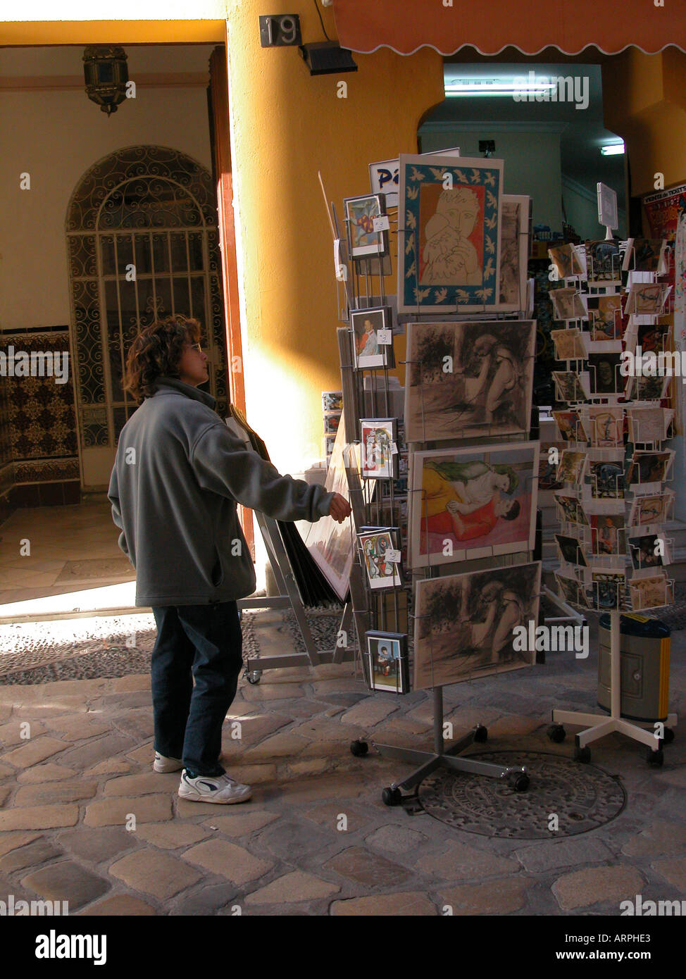 Une femme parcourt à travers les estampes de Picasso dans un magasin situé à proximité du Musée Picasso à Malaga Banque D'Images