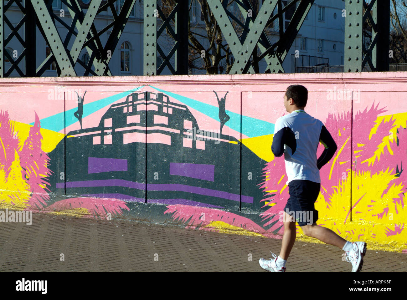 Homme qui court dans Primrose Hill London UK Europe au pont peint graffiti Banque D'Images