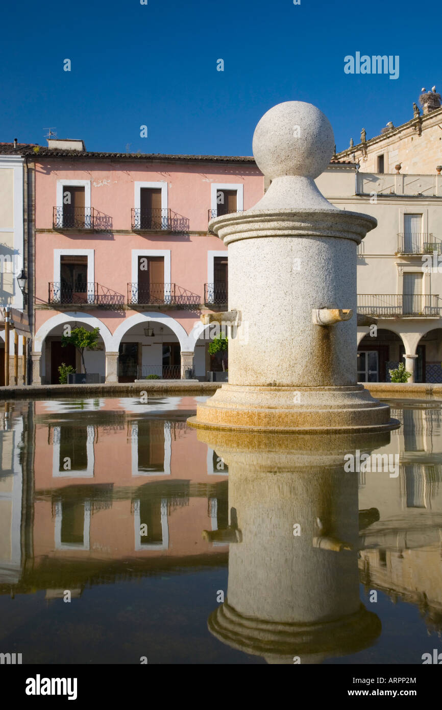 Trujillo, Estrémadure, Espagne. Fontaine de la Plaza Mayor, ses maisons colorées reflète dans l'eau. Banque D'Images