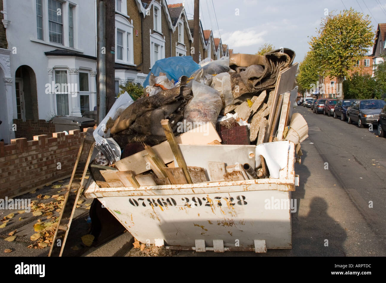 Sans licence et surchargé de Skip to road, pleine de détritus DIY en dehors de l'immobilier résidentiel privé Chingford North East London UK Banque D'Images