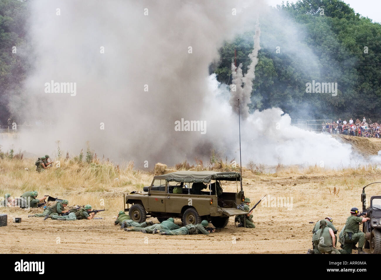 Reconstitution de la guerre du Vietnam.Grande explosion avec beaucoup de fumée grise, les militaires américains se cachent et tirent de derrière le spectacle de la guerre et de la paix des jeeps, Kent. Banque D'Images