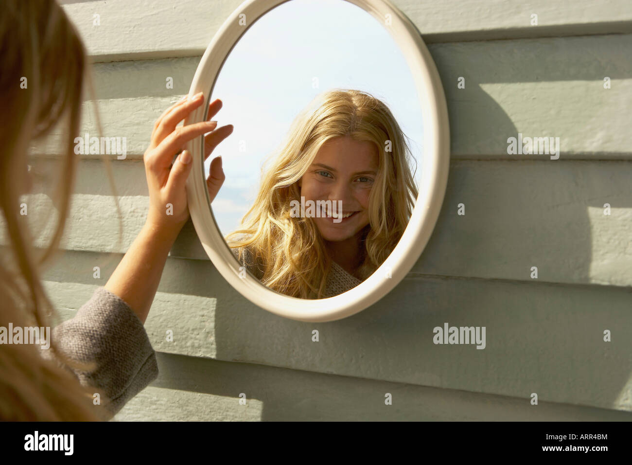 Jeune femme à l'extérieur de miroir dans Banque D'Images