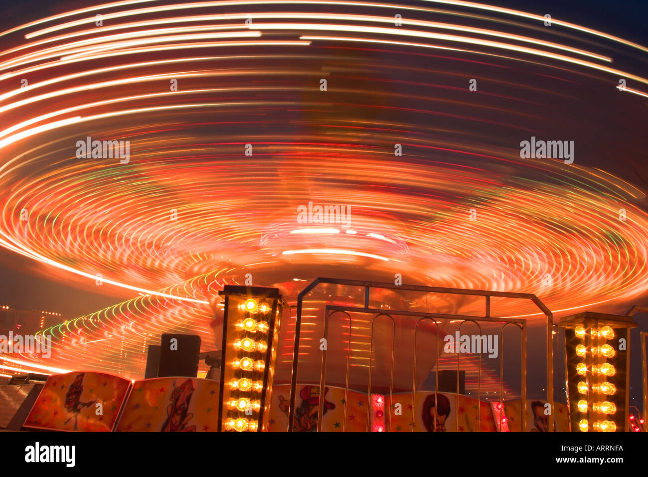 Une longue exposition d'un parc d'attraction de nuit. Banque D'Images