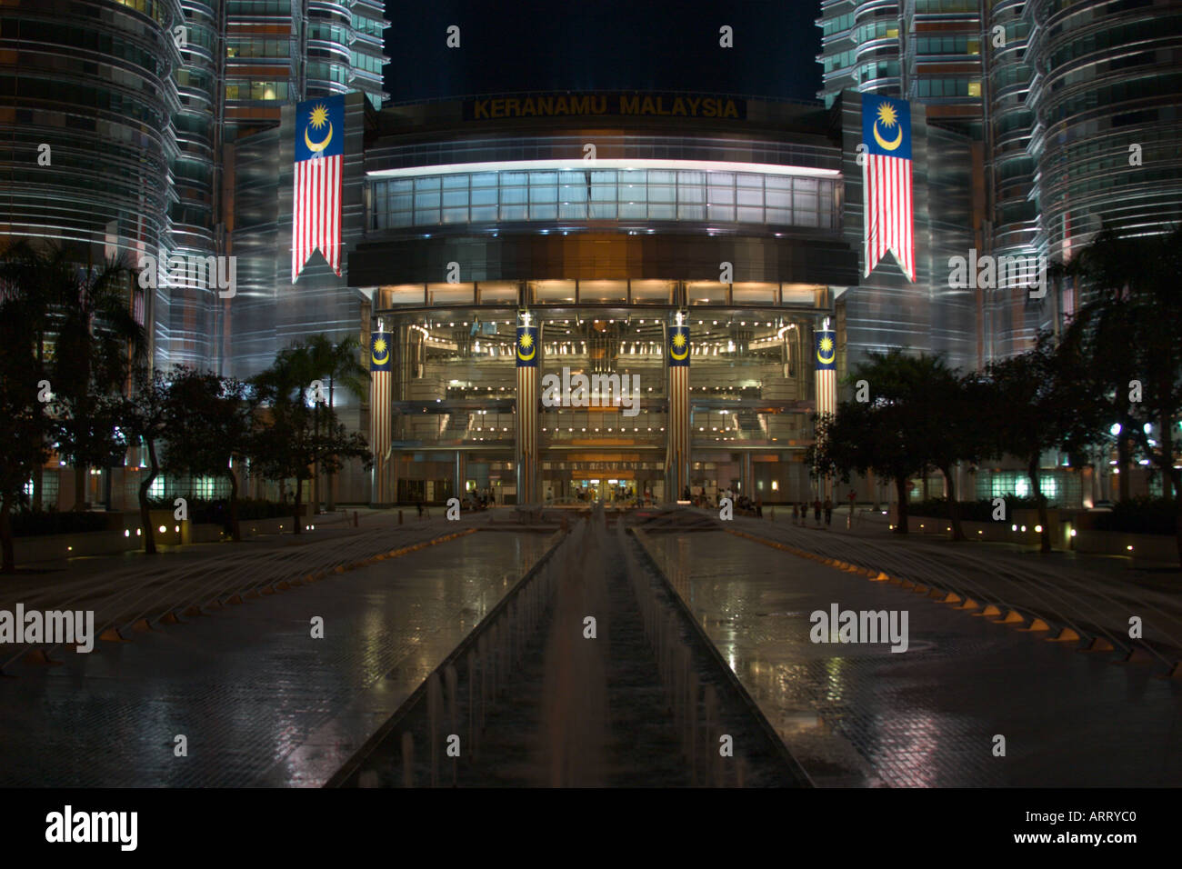 Base de Petronas Twin Towers dans la nuit avec un drapeau malaisien Banque D'Images