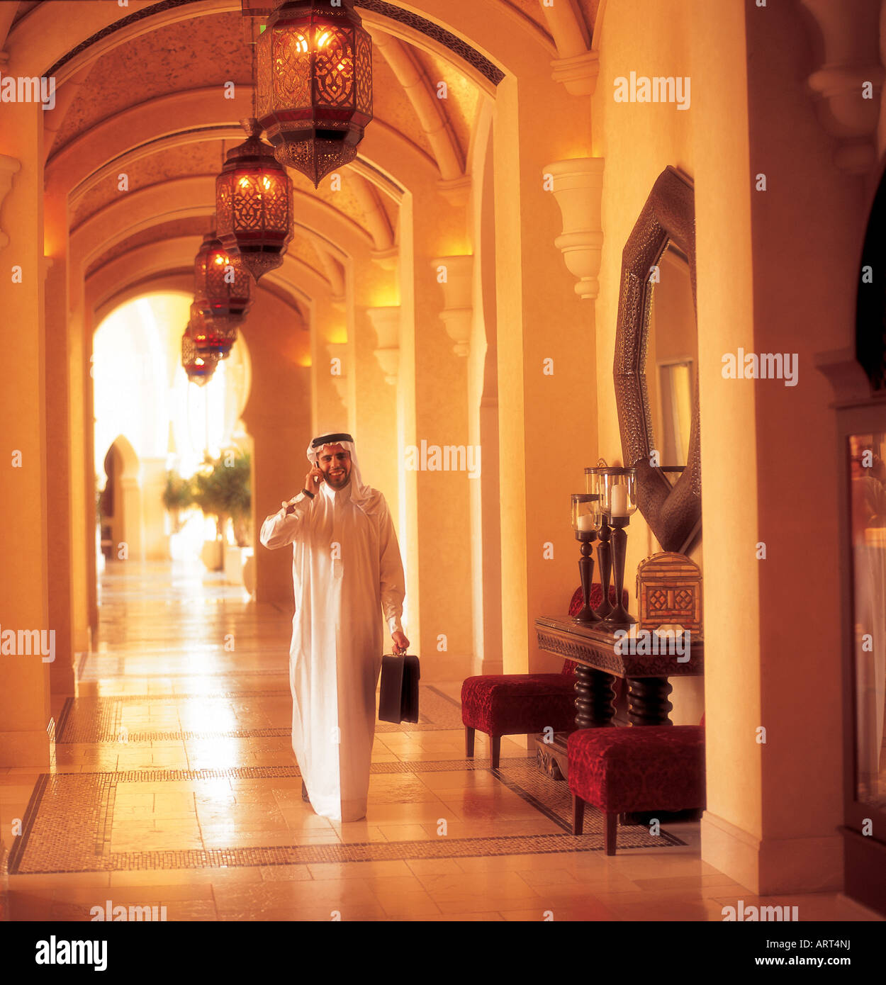 L'homme arabe avec porte-documents à l'aide d'un téléphone cellulaire Banque D'Images