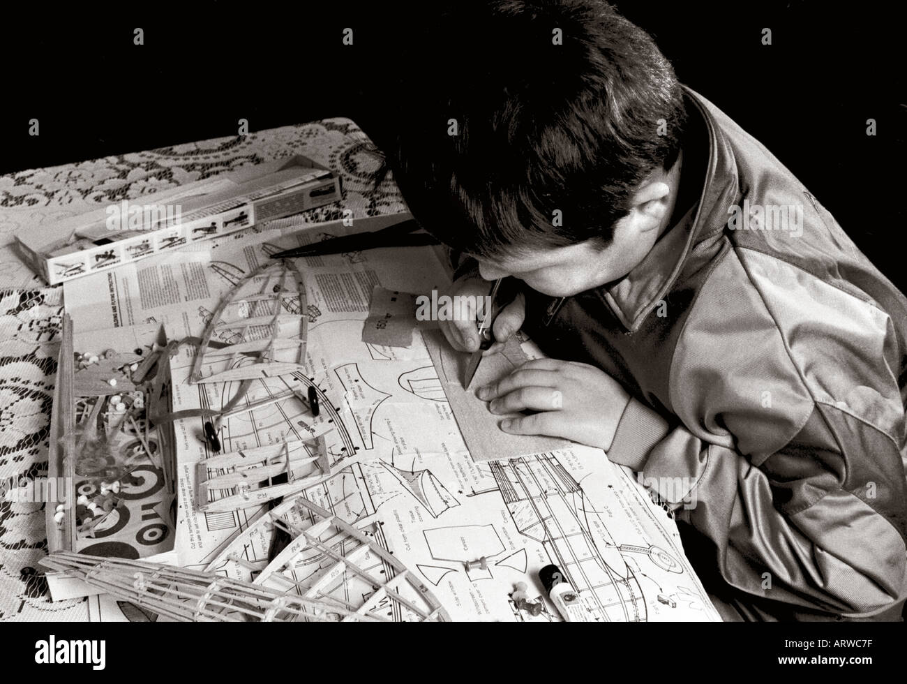 Garçon travaillant sur flying model kit d'aéronefs Banque D'Images