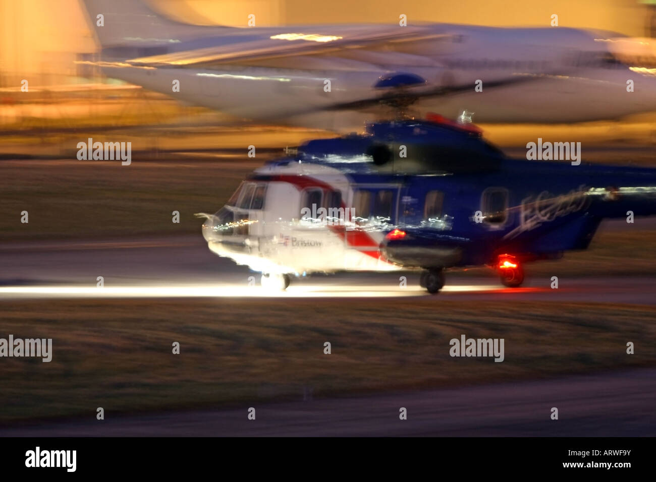 Bristows hélicoptère Super Puma des taxis le long de la piste de nuit à l'aéroport d'Aberdeen, Écosse, Royaume-Uni Banque D'Images