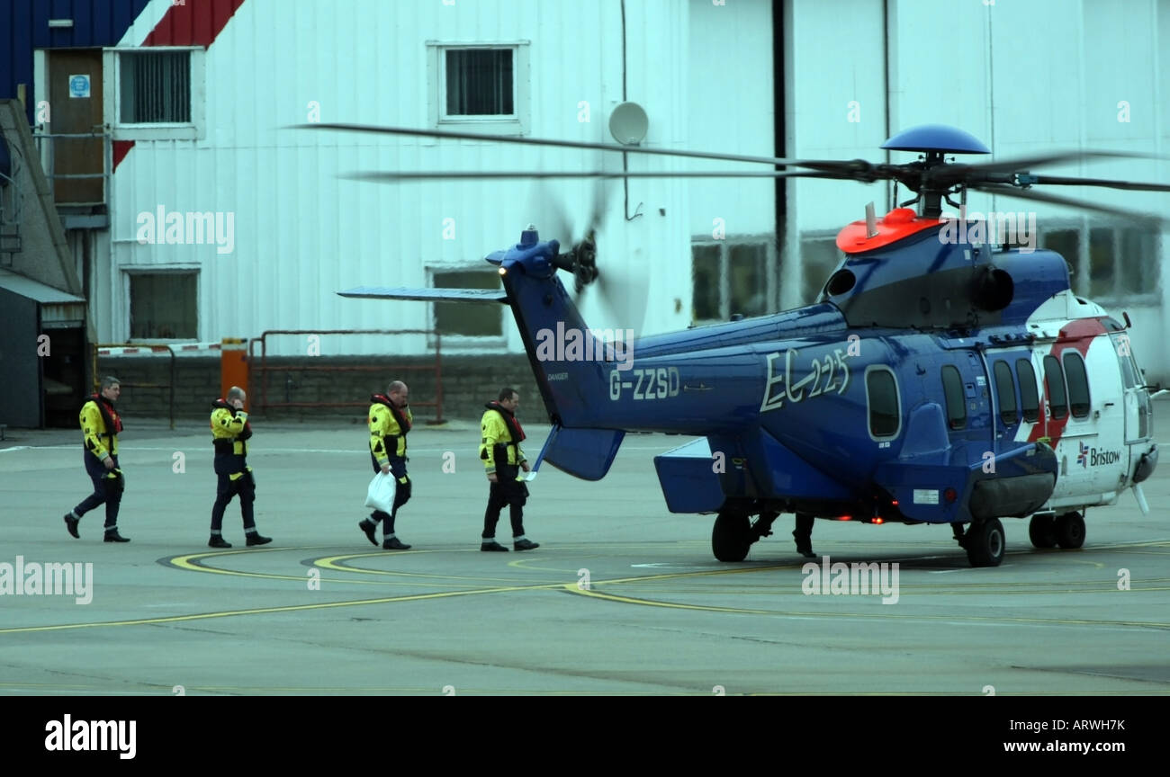 Les travailleurs du pétrole offshore à pied sur un Bristows vol en hélicoptère à l'aéroport d'Aberdeen, Écosse, Royaume-Uni Banque D'Images