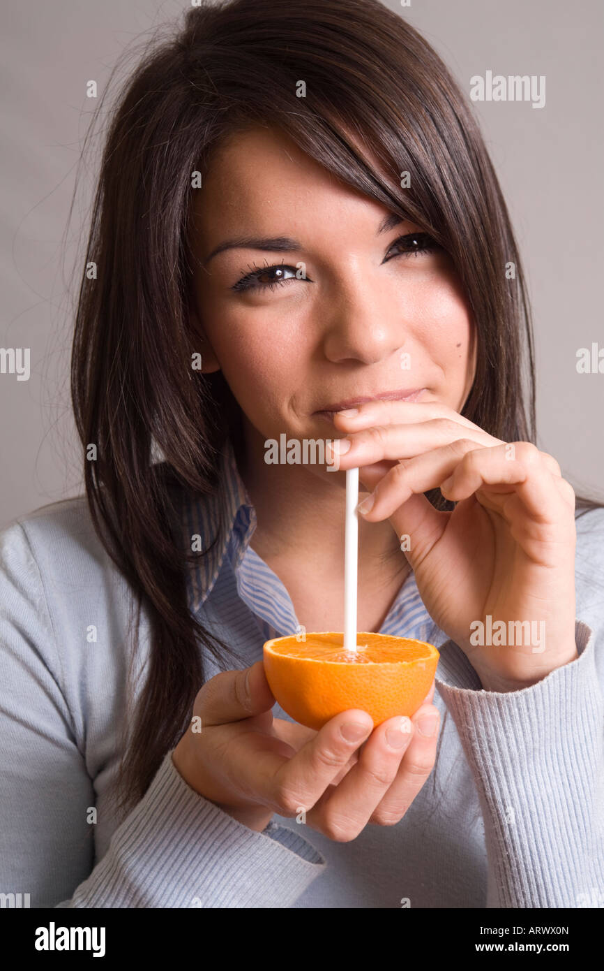 Mode de vie sain : young woman drinking orange juice Banque D'Images