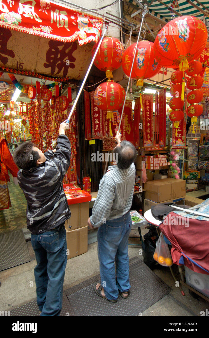 Un commerçant se bloque et lanternes décorations pour le Nouvel An chinois à l'extérieur de son magasin à Wanchai à Hong Kong 2005 Banque D'Images