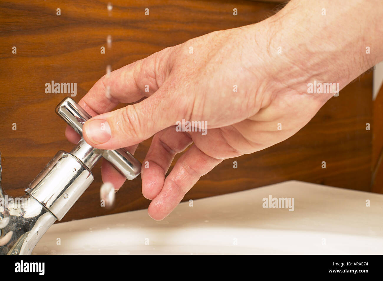 Se laver les mains de l'homme du robinet tournant Banque D'Images