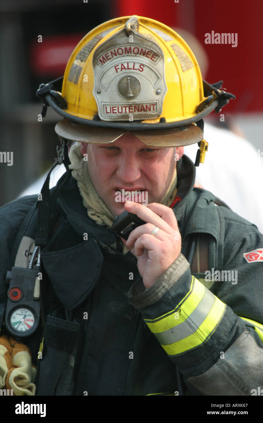 Fire fighter dans un casque jaune Lieutenant s'agit sur la radio Banque D'Images
