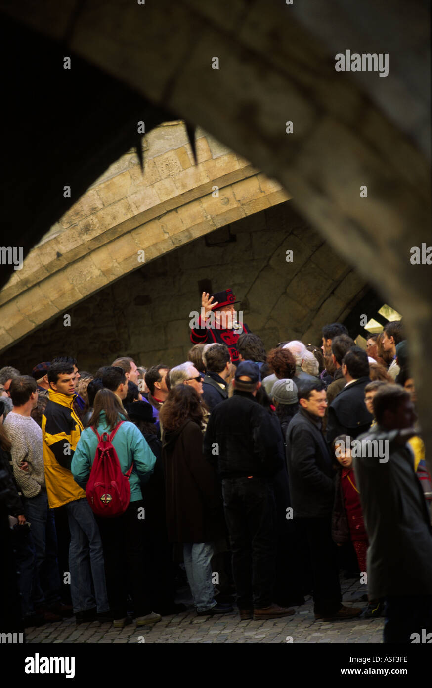 Un conductuing beefeater un tour autour de la tour de Londres pour une foule de touristes Londres Angleterre Banque D'Images