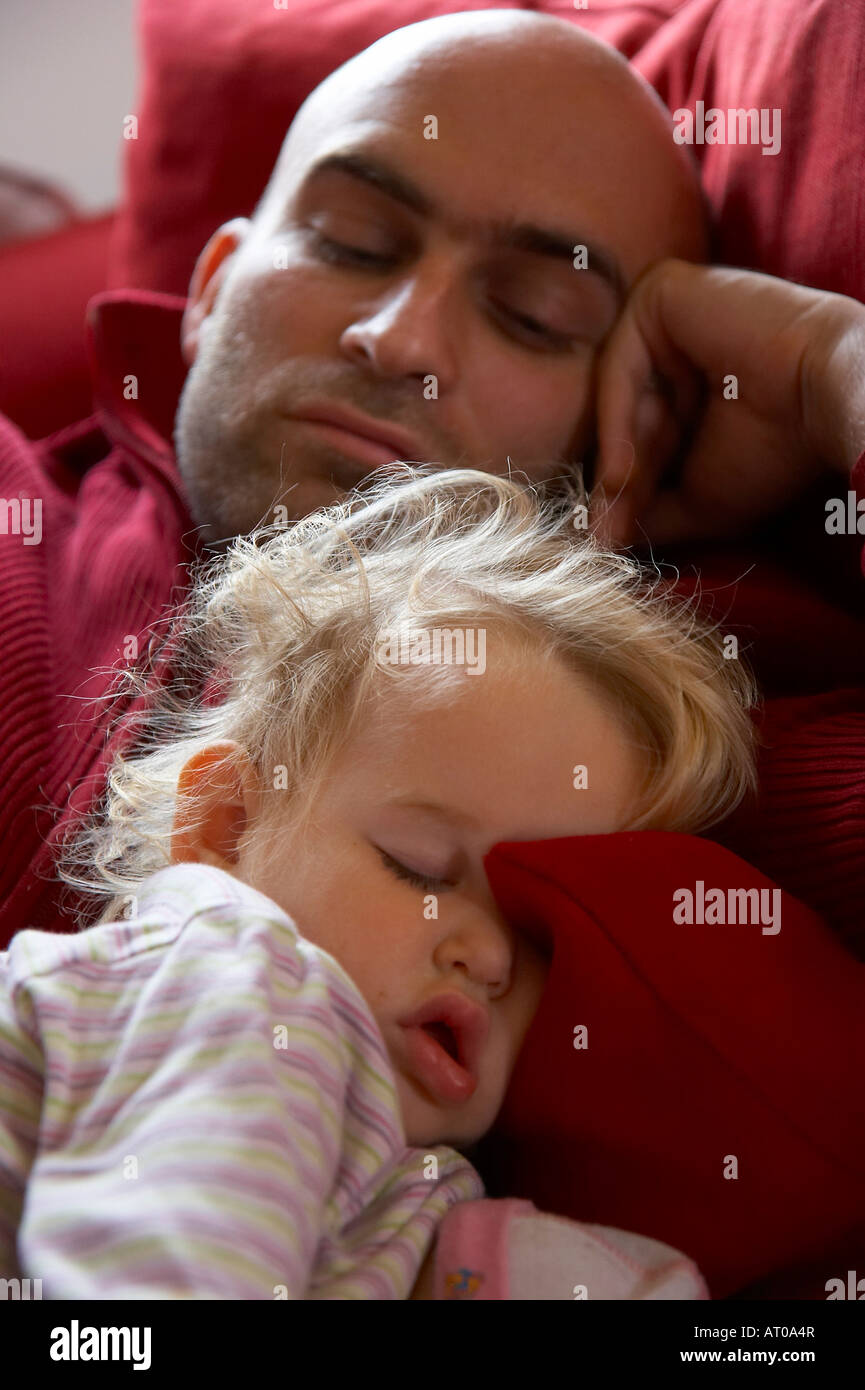 Petite fille dormir avec père sur un oreiller rouge Banque D'Images