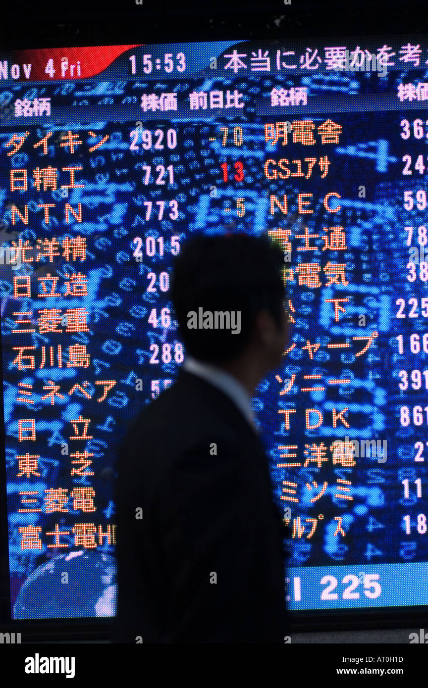 L'homme à la recherche de stocks et des actions les prix sur grand écran dans Tokyo Japon Banque D'Images