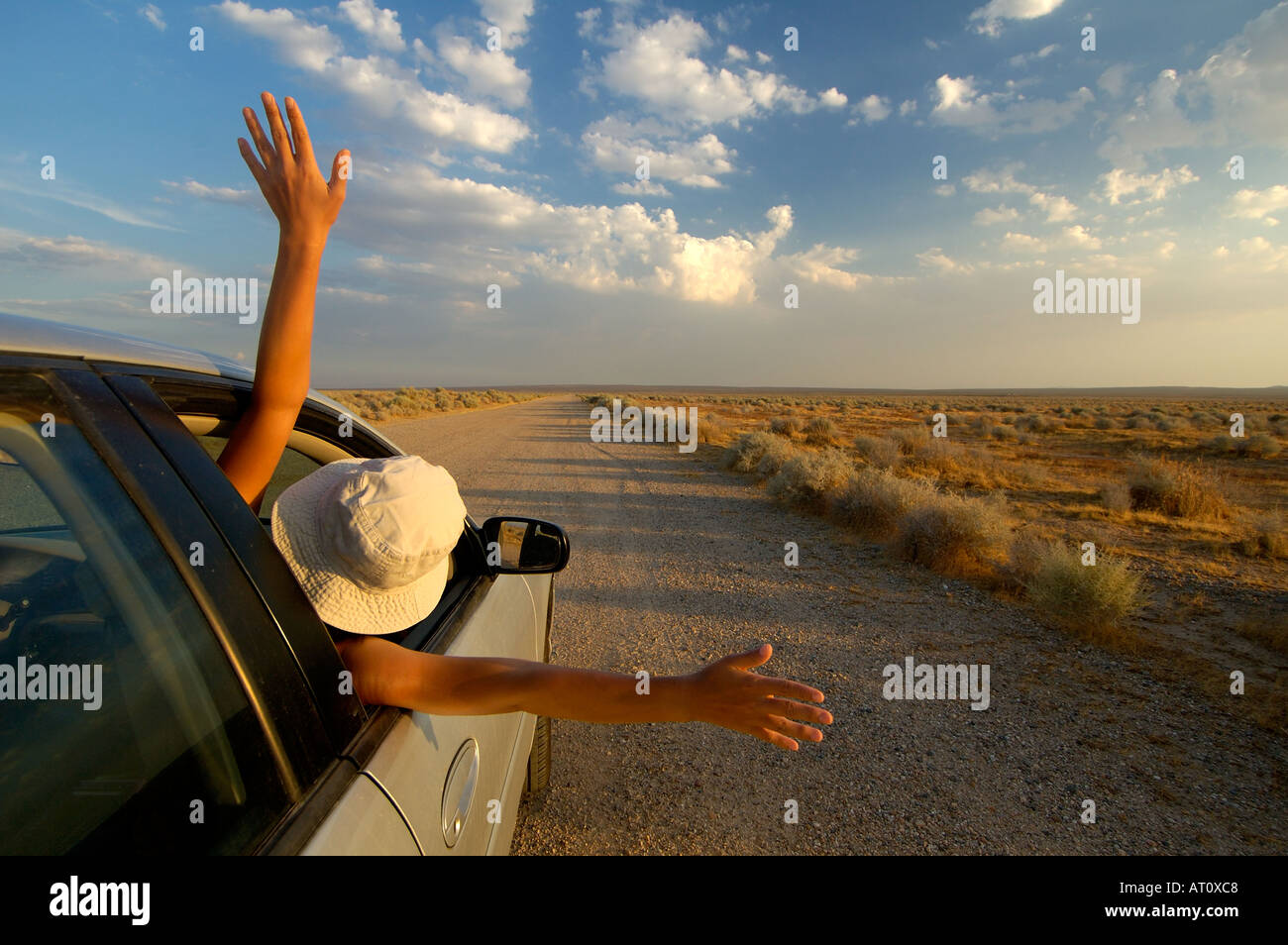 Une femme se penchant sur le côté de la voiture dans l'euphorie, California, USA Banque D'Images