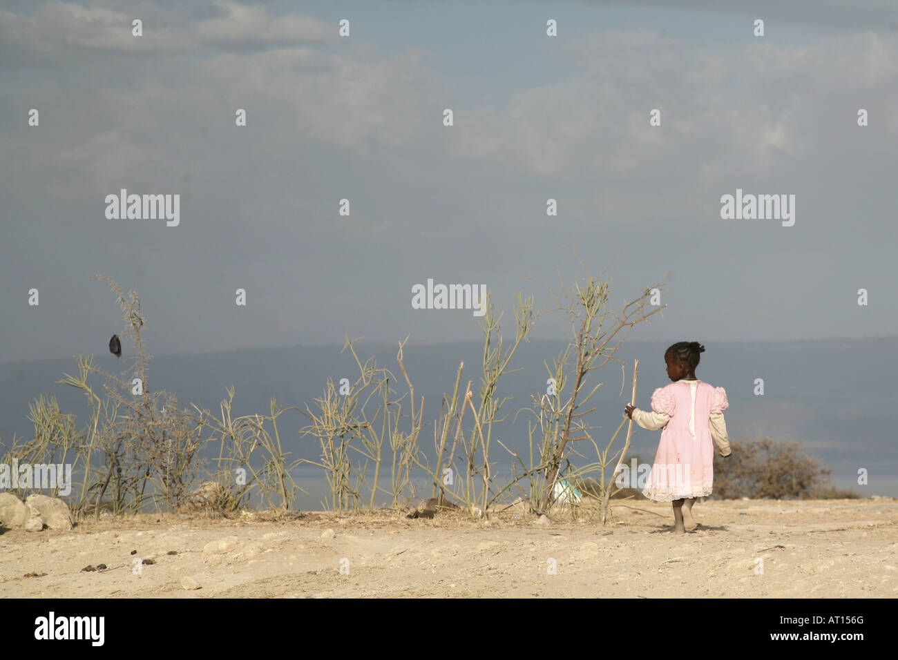 Jeune fille africaine en robe rose avec vue sur le lac Banque D'Images