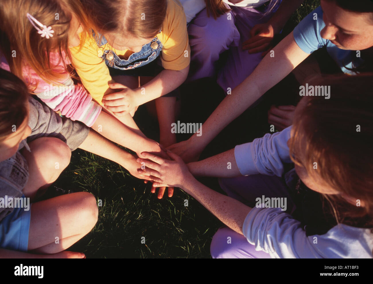 Les enfants les mains dans un jeu d'empilage portant des vêtements colorés Banque D'Images