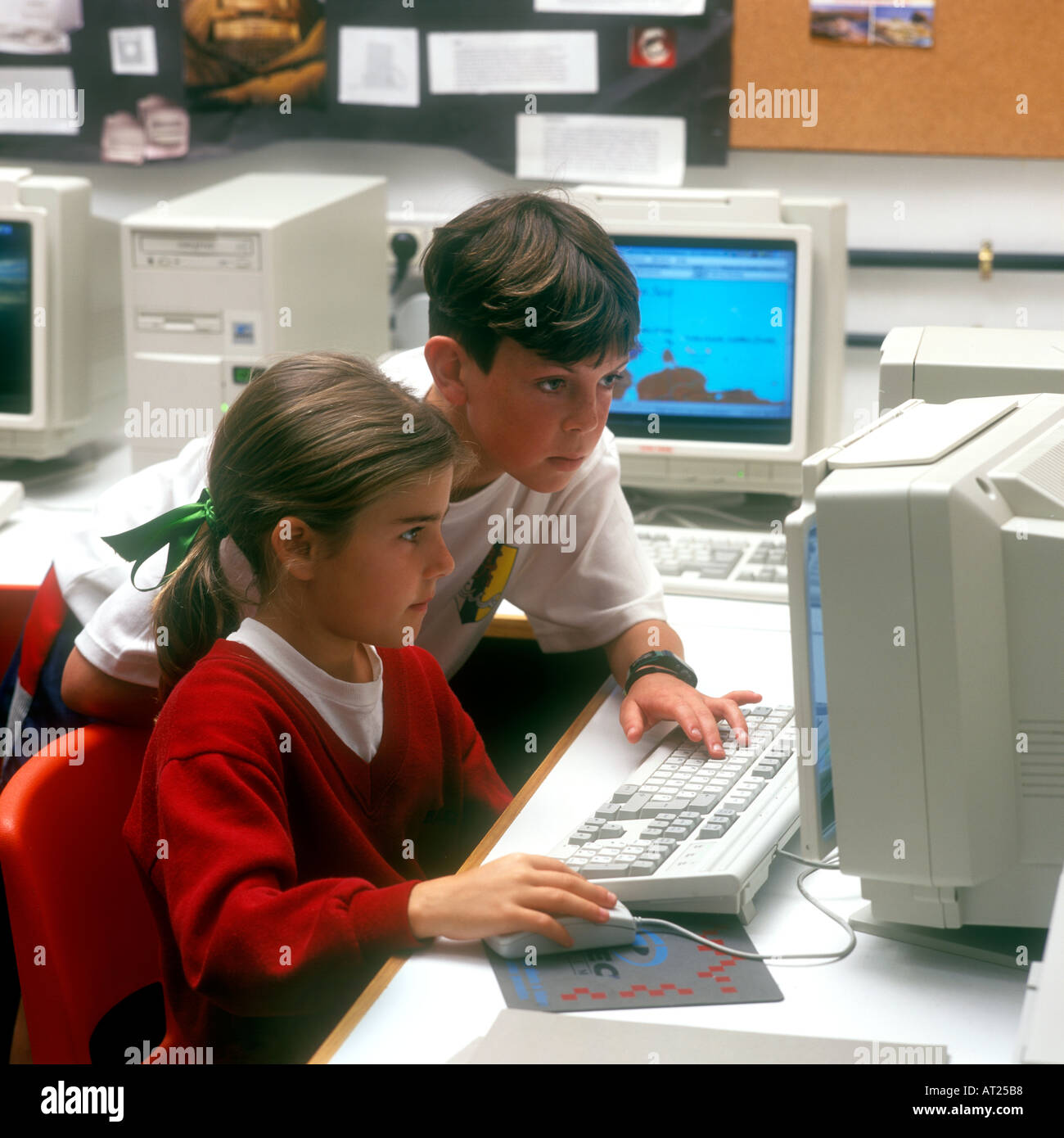 Computer 1990's rétro école classe informatique Junior 8-10 ans école fille et écolier élèves travaillant ensemble école précoce classe informatique de technologie Banque D'Images