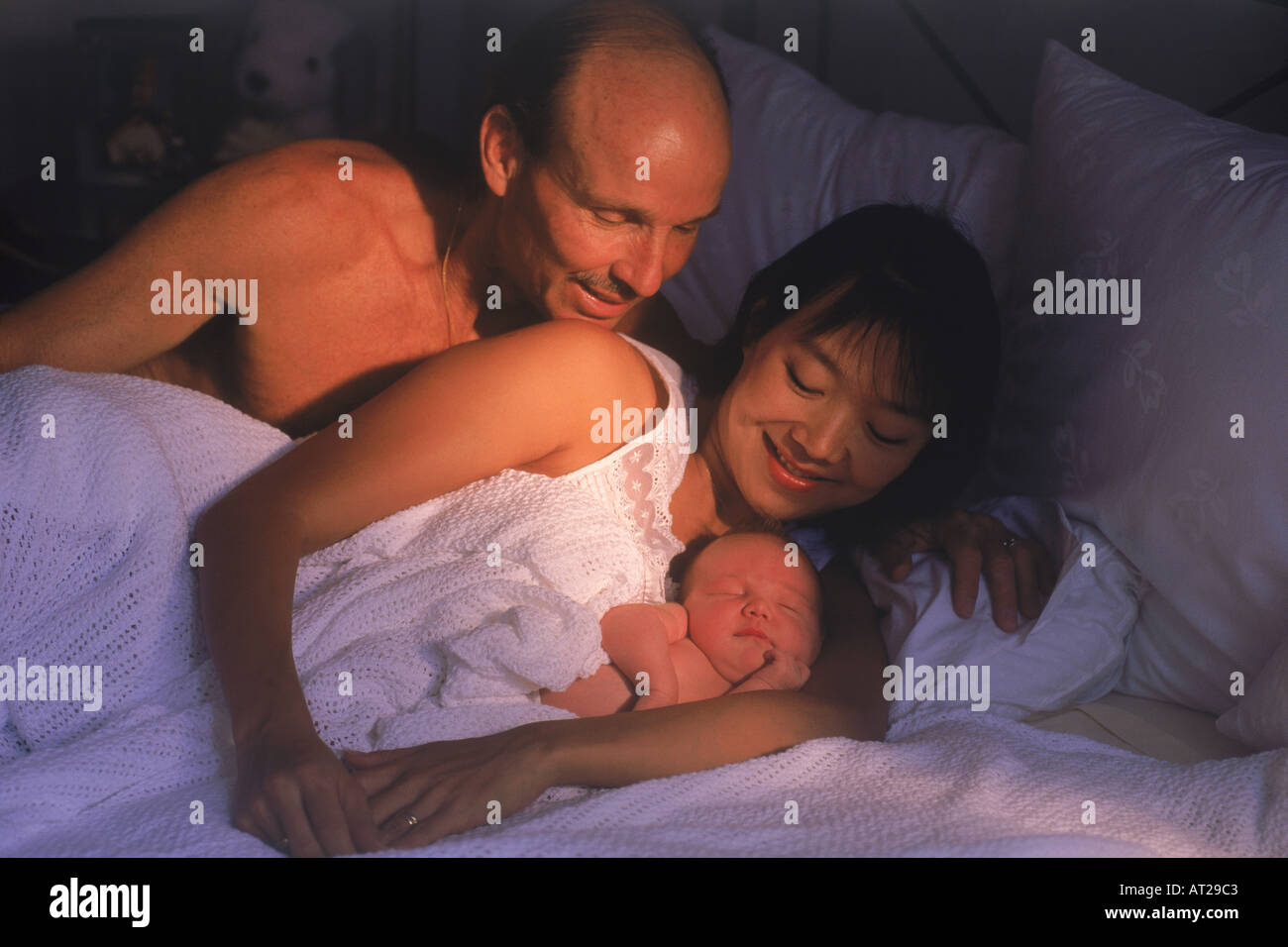 Portrait père et mère de l'Asie au lit avec bébé nouveau-né Banque D'Images
