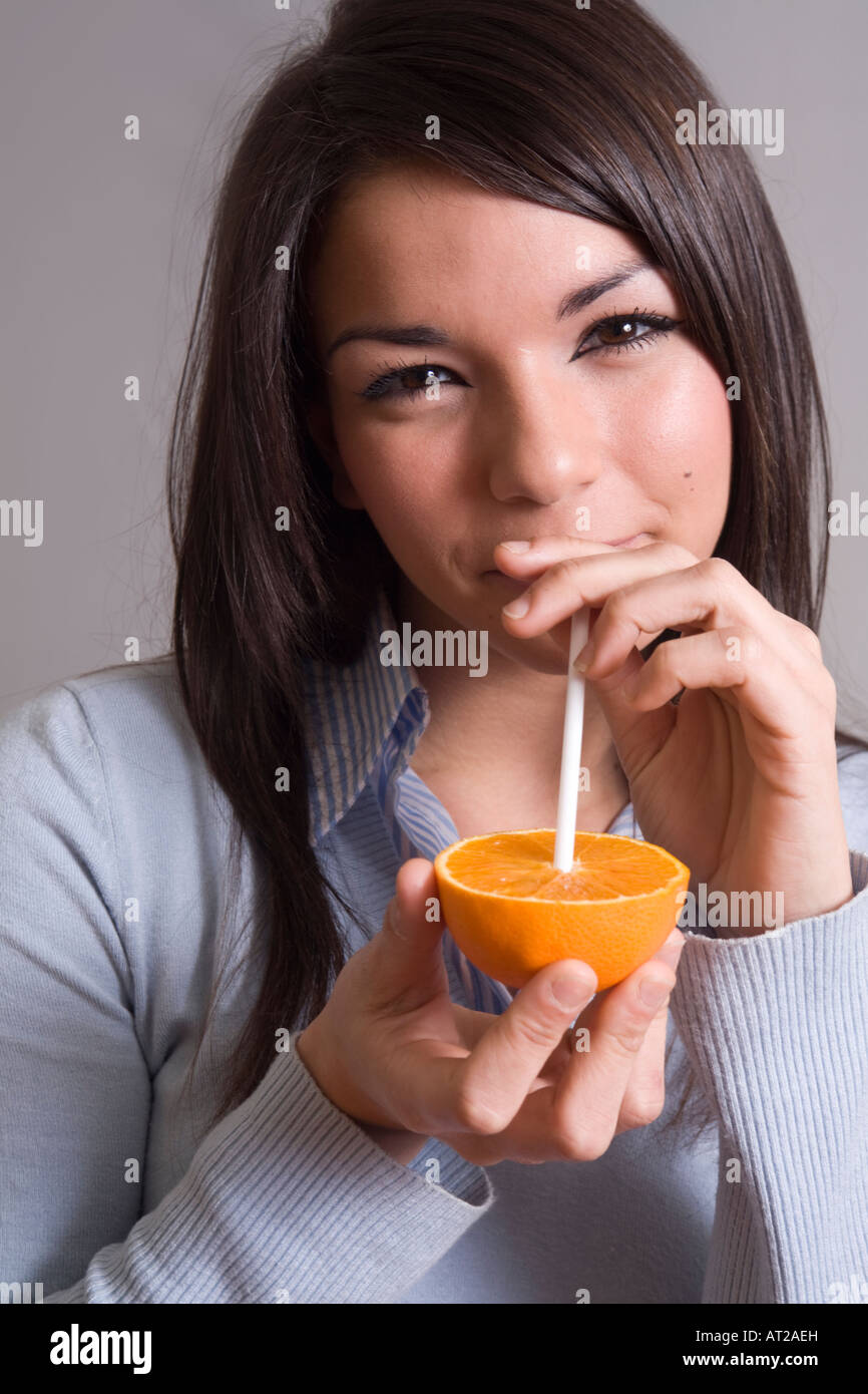 Mode de vie sain : young woman drinking orange juice Banque D'Images