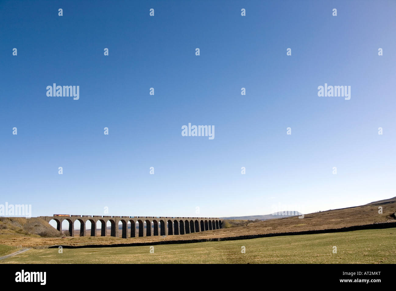 Un train de marchandises traverse Ribblehead viaduc qui porte les s'installer à Carlisle railway line, Yorkshire, UK Banque D'Images