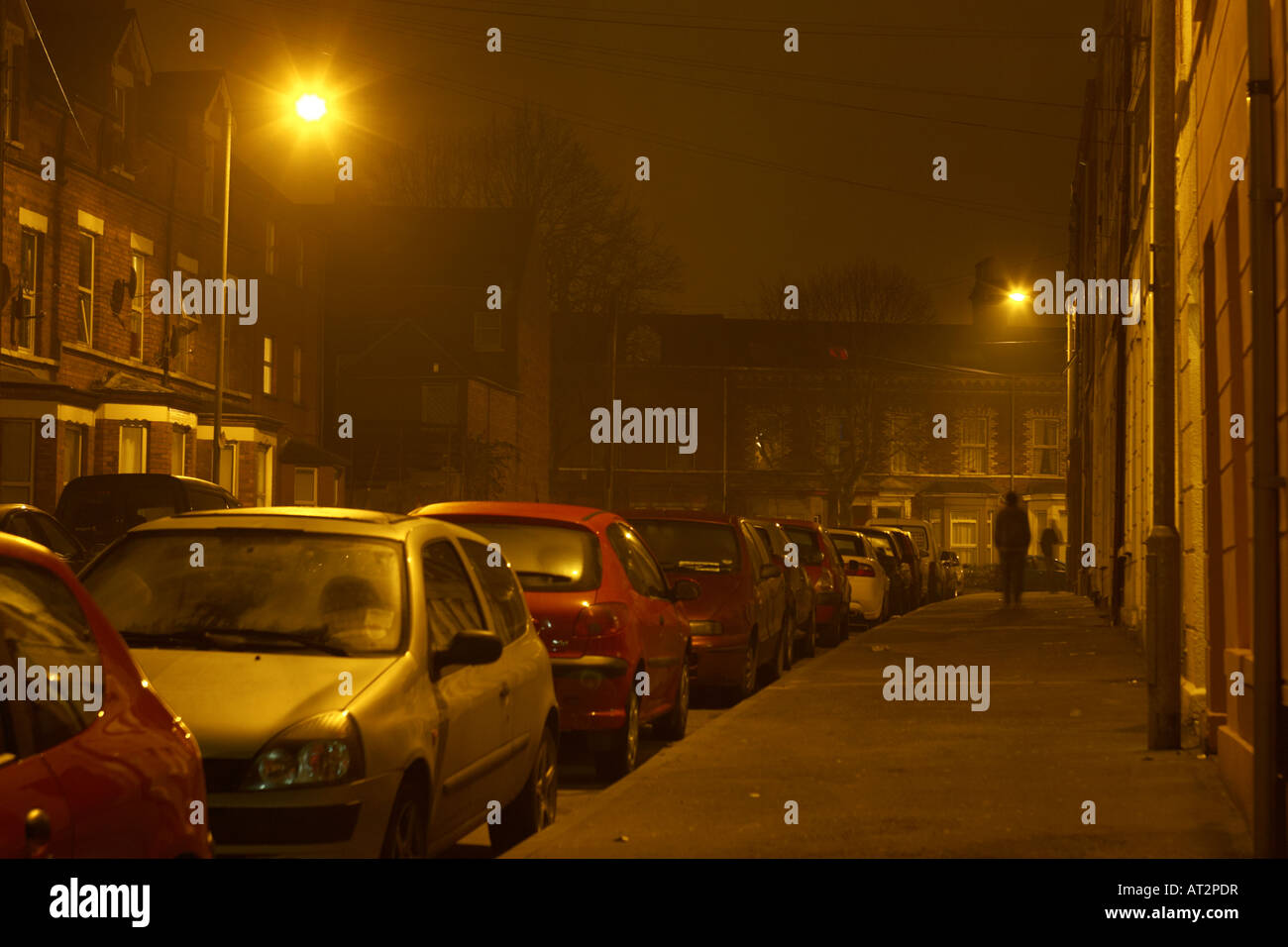 L'homme suite à un autre homme sous l'éclairage sur la rue la nuit sombre  étroit à Belfast Photo Stock - Alamy