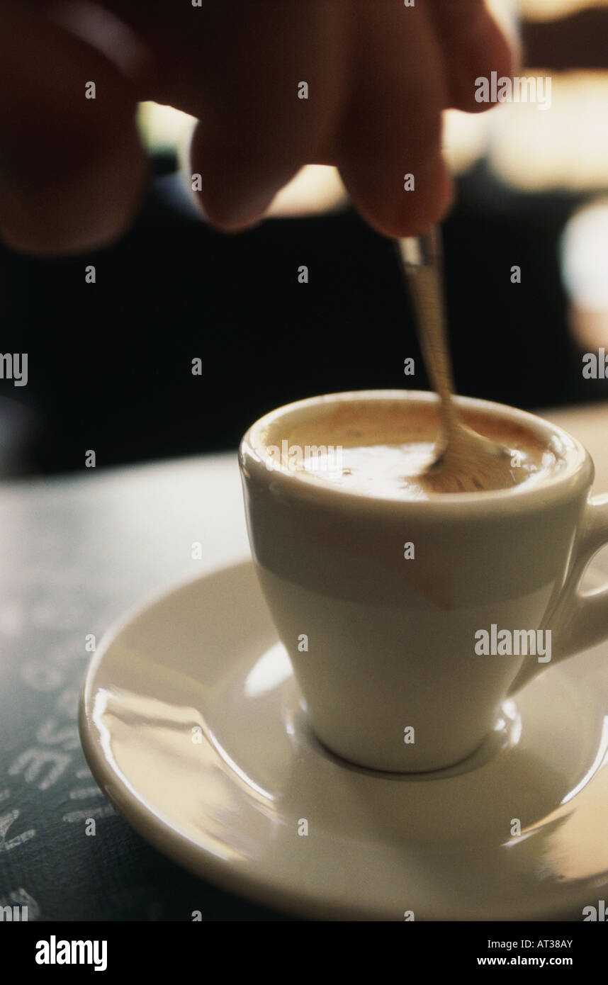 Une personne en remuant une tasse de café Banque D'Images